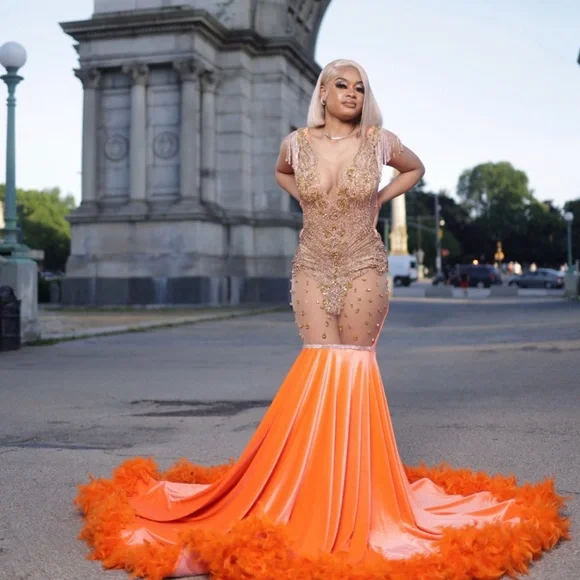 Orange Long dress with feathers at the bottom and open back with gold top  detail